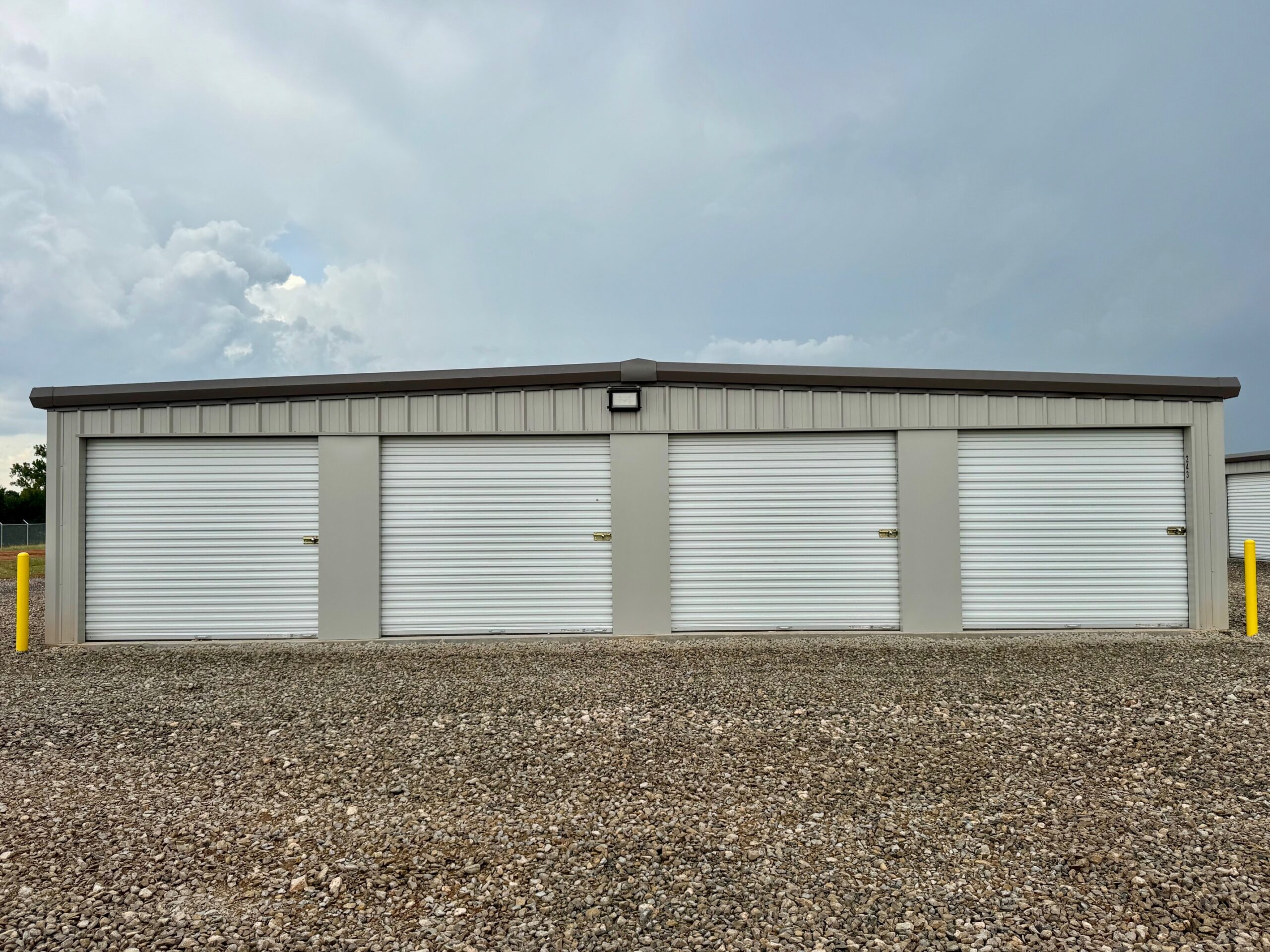 Four drive-up storage units with white roll-up doors