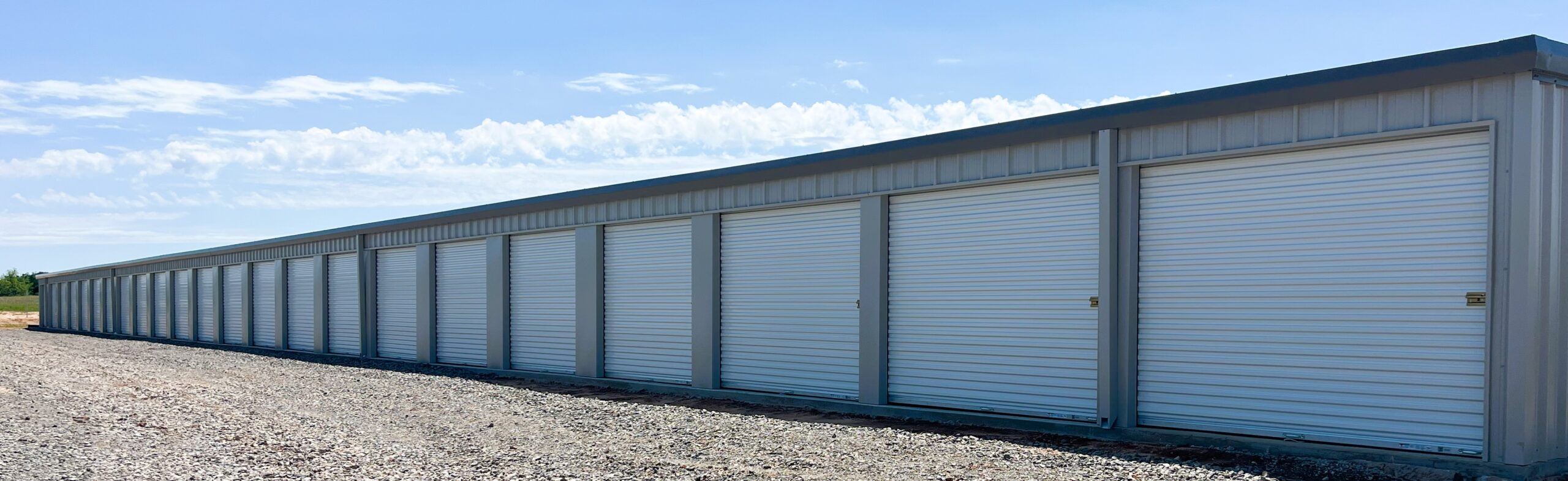 Long building of storage units with large roll-up doors